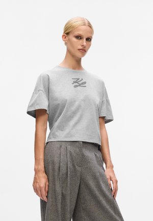 Gray cropped t-shirt made of cotton with a round neckline and short sleeves, featuring a decorative embroidered detail on the front.