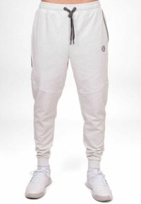 Hellgraue Sweatpants mit elastischem Bund, Kordelzug, Seitentaschen, gerippten Bündchen und einem kleinen Logo-Patch am Hüftbereich.