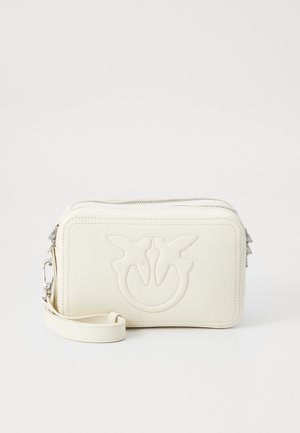 Borsa a polso in pelle crema con logo in rilievo di due uccelli, zip argentate e tracolla removibile su sfondo bianco.