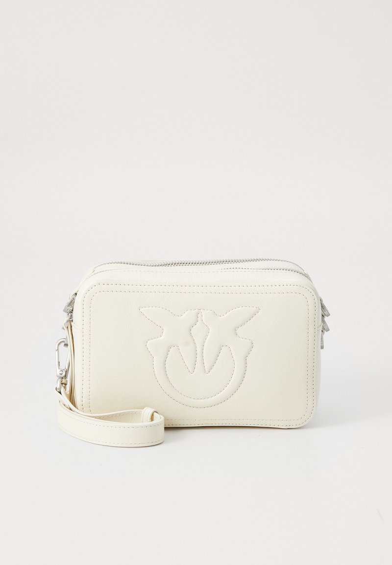 Borsa a polso in pelle crema con logo in rilievo di due uccelli, zip argentate e tracolla removibile su sfondo bianco.