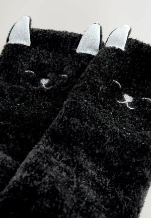 Schwarze, flauschige Socken mit weicher Textur, die mit gestickten Katzen-Gesichtdetails und glänzenden silbernen Ohren versehen sind.