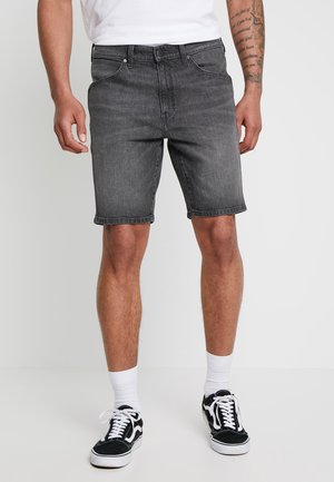 Shorts de mezclilla gris con corte recto, trabillas, cinco bolsillos y costuras en contraste, combinados con zapatillas negras y calcetines blancos.