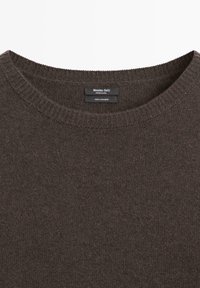 Ciemnobrązowy sweter z kaszmiru z okrągłym dekoltem, z prążkowanym kołnierzem i wszytą wewnątrz metką marki „Massimo Dutti”.