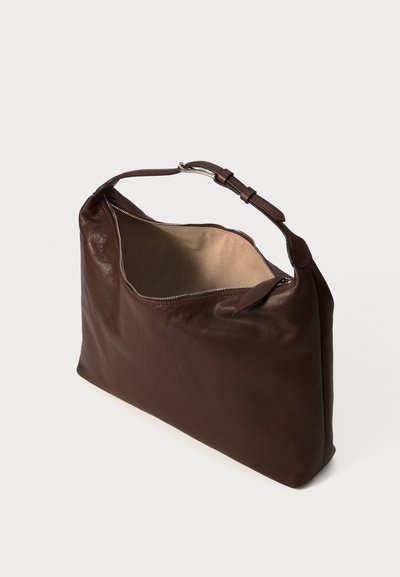 Brown leather shoulder bag with adjustable strap, zipper opening, and beige fabric interior, standing on white background.