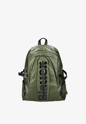 Olivgrüner Nylon-Rucksack mit mehreren Reißverschlussfächern, schwarzen Akzenten und verstellbaren Gurten. Auf der Vorderseite prangt ein auffälliges Logo.