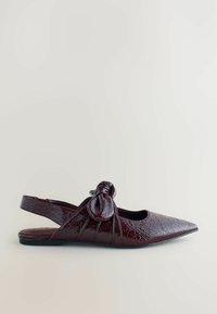 Mörk burgunderfärgad patentläderplatt sko med spetsig tå, slingback-rem och dekorativ knutdetalj på sidan.