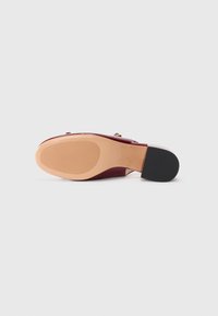 Talpa de shoe din piele lacuită roșie cu un design îngustat și un toc din cauciuc negru. Textură netedă cu o arcadă ușor curbată.