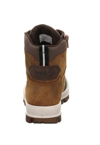 Brązowe zamszowe botki za kostkę z teksturowanym kołnierzem z tkaniny, białą podeszwą oraz czarno-białą pętelką. Z tyłu znajduje się logo marki.