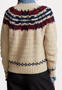 Jersey de punto en color crema con un yugo estampado en azul marino, rojo y blanco. Presenta puños y dobladillo de canalé, tela texturada y acentos en forma de diamante.