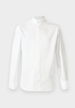 Chemise blanche à manches longues en coton, avec un col haut et une fermeture à boutons, texture lisse et coupe ajustée.