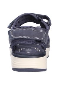 Sandale bleu marine avec brides réglables en Velcro, semelle intérieure rembourrée taille 37 et semelle blanche vue de dos.