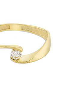 Bague en or avec un seul diamant rond serti dans un design courbé sur un bandeau lisse, présentée sur un fond blanc.