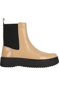 Bottine en cuir verni beige avec des panneaux élastiques noirs sur les côtés et une semelle en caoutchouc noir texturé, dotée d'une languette à l'arrière.