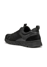 Scarpe sportive nere caratterizzate da una combinazione di pelle liscia e testurizzata, suola pronunciata con scanalature e un'allacciatura sul tallone.