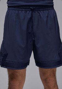 Shorts sportivi blu navy con vita elasticizzata, cordoncino e accenti laterali a contrasto. Realizzati in un tessuto morbido e leggero.