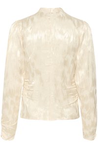 Cream-colored long-sleeve blouse with a textured, shiny fabric featuring subtle patterns and gathered detailing at the sides.