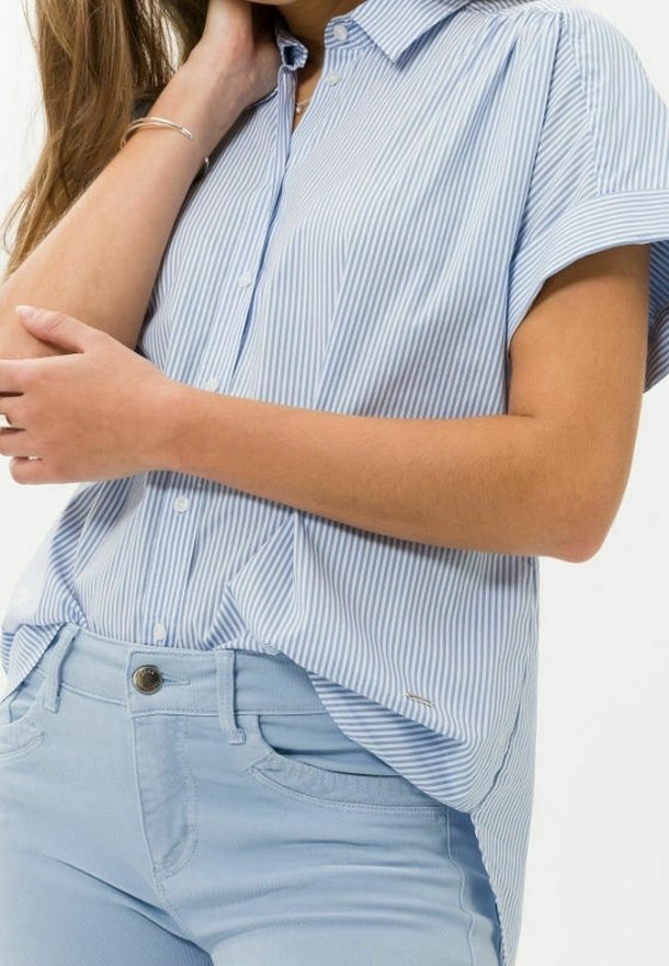 Camicia a maniche corte a righe blu chiaro e bianco con colletto, abbinata a jeans blu chiaro, dotata di tasca frontale e leggero effetto texture.