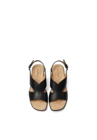 Sandali in pelle nera con design a intaglio, punta aperta, cinturino alla caviglia e soletta in suede beige. Texture liscia e minimi accenti hardware.