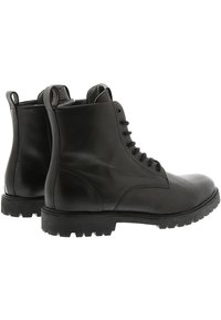 Botas de tobillo de cuero negro con suela robusta, con punta redonda, cordones en la parte delantera y tiradores en la parte trasera. Textura simple y suave.