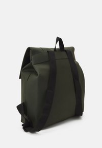 Sac à dos vert à rabat, fabriqué en matériau durable, doté de bretelles noires et d'un design minimaliste avec une forme structurée.