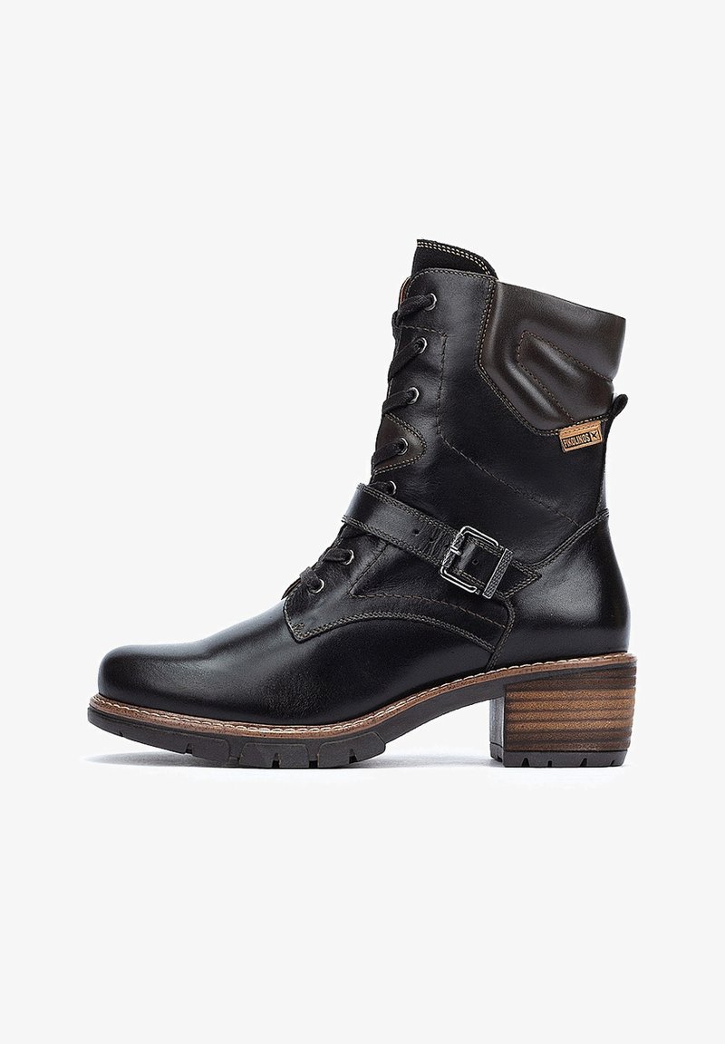 Schwarze Leder-Ankle-Boots mit Schnürung vorne, einem geschnallten Riemen und einem Blockabsatz aus Holz. Verfügt über einen gepolsterten Schaft und dezente Nähte.