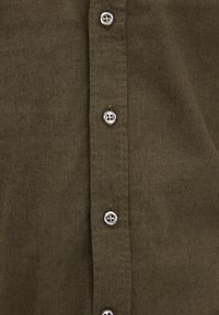 Olijfgroene, textuurstof shirt met een knoopsluiting aan de voorkant met zes zilveren ronde knopen en een rechte zoom.