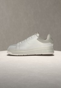 Λευκό sneaker χαμηλού προφίλ με ανοιχτό γκρι επενδεδυμένο γιακά και χοντρή σόλα, εμφανίζεται σε πλαϊνή όψη σε επίπεδη επιφάνεια με ουδέτερο φόντο.
