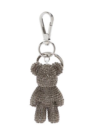 Breloczek z metalowym, srebrnym zapięciem, trzymającym małą figurkę misia pokrytą ciemnymi, błyszczącymi kryształkami.