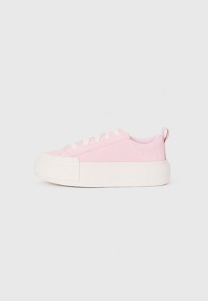 Baskets en toile rose avec une surface texturée, bout rond et semelle en caoutchouc blanc épais. Dotées de lacets blancs et d'une poignée au niveau du talon.