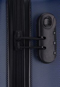 Valigia rigida blu navy con superficie testurizzata, zip nera e meccanismo di chiusura nera con due zip e impugnatura tattile.