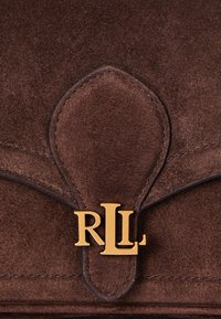 Ruda zomšinė rankinė su išlenktu uždengimu, turinti auksinį "RLL" logotipo užsegimą. Lygi tekstūra su siuvinėtomis detalėmis aplink kraštus.