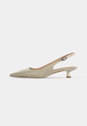 Chaussure slingback beige à bout pointu avec talon bas courbé et bride réglable à boucle sur fond uni.