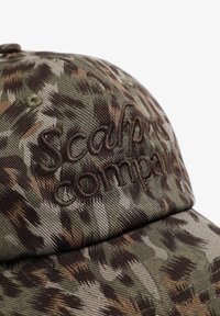 Gorra de béisbol de camuflaje con el logo bordado "Scalpers Company", que presenta tonos verdes, marrones y grises en un tejido texturizado.