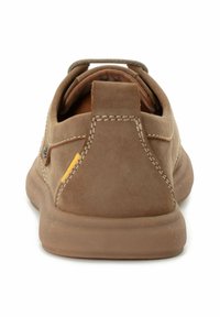 Zapatos de ante marrones con un talón redondeado, acento amarillo en contraste y costuras visibles. Textura suave y suela de goma. Diseño casual.