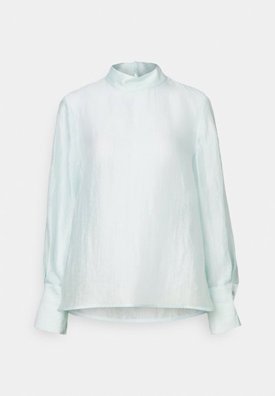 Blusa azzurro chiaro a maniche lunghe con colletto alto, texture morbida e vestibilità rilassata. Presenta polsini con bottoni e orlo dritto.