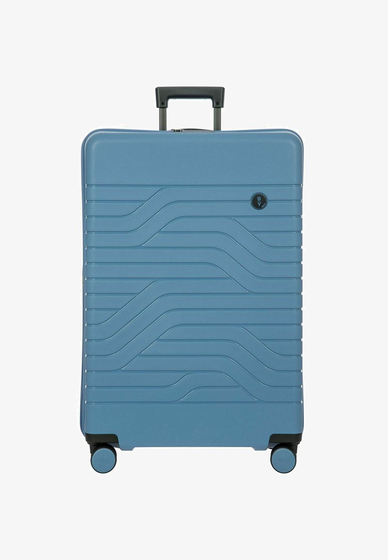 Valigia rigida di colore blu chiaro, con un motivo a onde, maniglia nera e quattro ruote per la mobilità. Forma rettangolare compatta.
