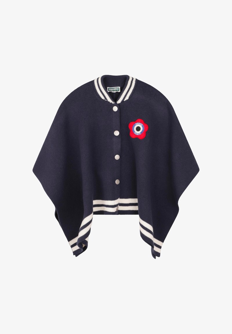 Poncho en tricot marine avec col et ourlet rayés, arborant un patch de fleur rouge avec un centre noir et des accents blancs, cinq boutons à l'avant.