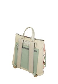 Mochila beige y verde menta con acentos texturizados, herrajes metálicos, asas dobles y un bolsillo delantero con cremallera. Presenta correas decorativas.