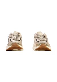 Sneakers leggere con tomaia in rete beige, dettagli neri, particolari riflettenti, suola in gomma testurizzata e lacci a contrasto.