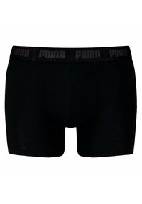 Boxer shorts de algodón negro con un diseño ajustado. Presenta una gruesa cinturilla negra con el logo "PUMA" en un patrón repetido.