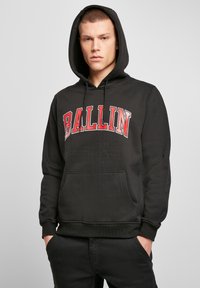 Čierna mikina s klokaním vreckom, na prsiach je veľký červený nápis "BALLIN". Vyrobená z mäkkého materiálu, má rebrované manžety a minimalistický dizajn.