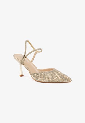 Zapato dorado de tacón alto con tira trasera y puntera puntiaguda, decorado con perlas y pequeños cristales en un patrón a rayas.