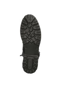 Suela de bota de goma negra con diseño texturizado, que presenta un patrón en zigzag y cruzado para mayor tracción. Tacón reforzado y logo de la marca presente.