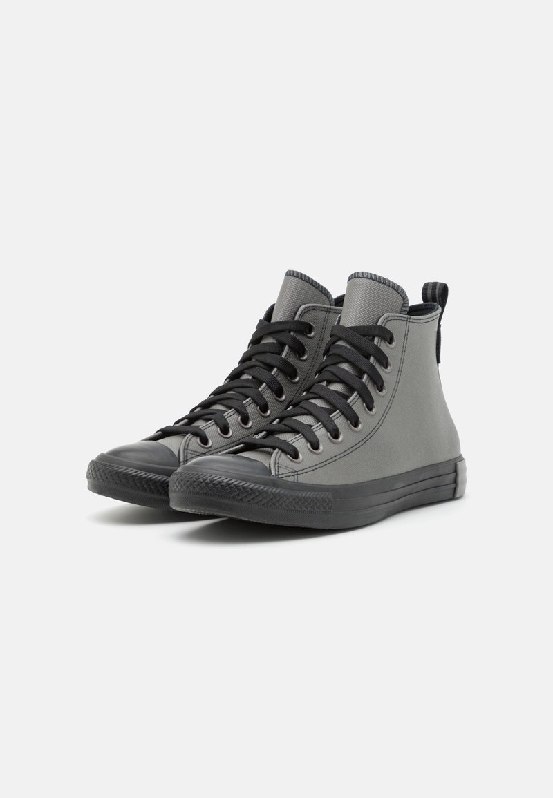 Sneakers alte grigie realizzate in materiale canvas, con lacci neri, un puntale in gomma testurizzato e una suola in gomma con motivo.