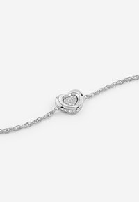 Bracciale d'argento con un ciondolo a forma di cuore. Il ciondolo presenta un piccolo cuore all'interno ed è abbellito con cristalli trasparenti lungo i bordi.