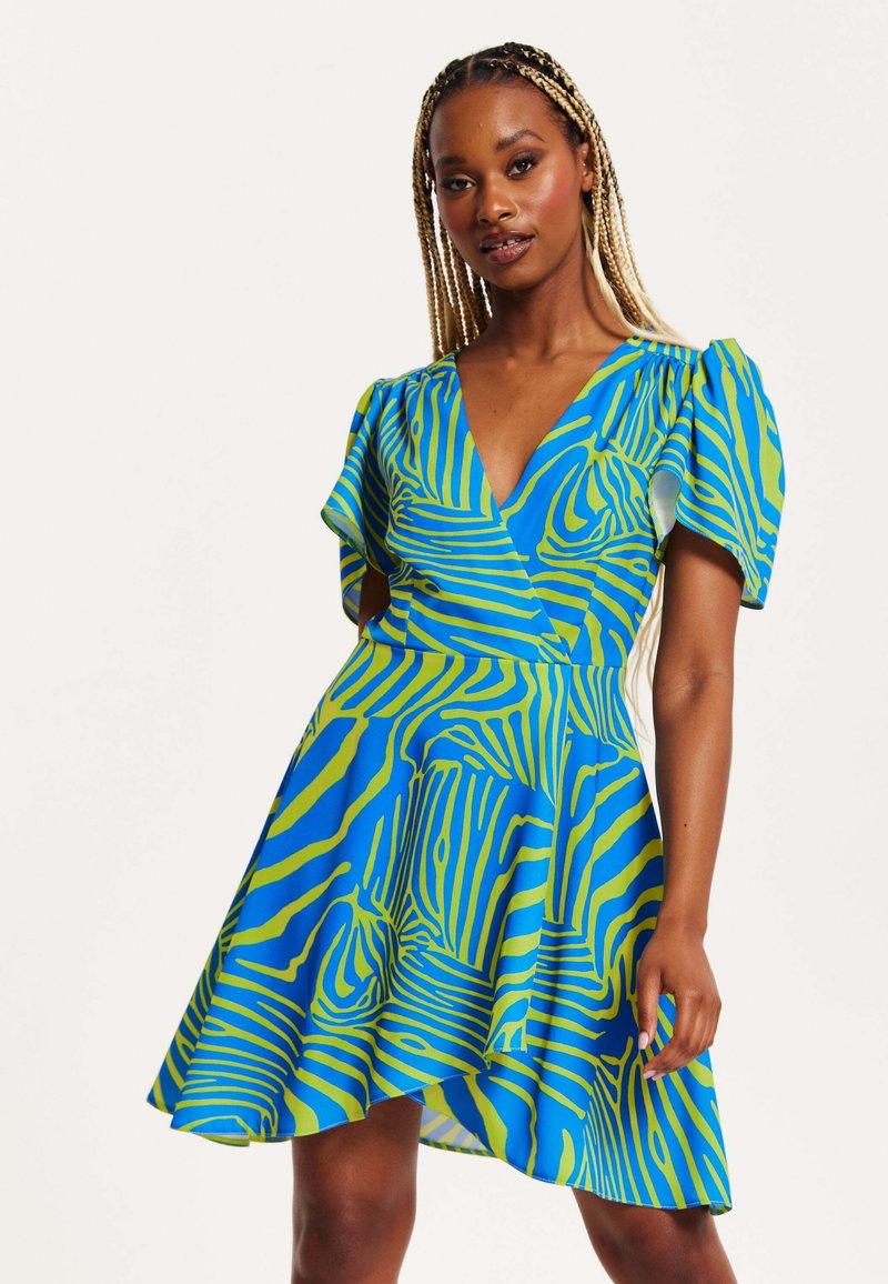 Short-sleeve dress featuring a deep V-neck, made of bright blue fabric with green, striped patterns and a flared skirt.