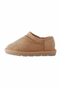 Tanslipper gemaakt van zacht stof, met een lage snit, ronde neus en een gestructureerde zool met een dikke rubberen basis voor grip.