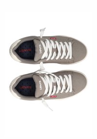 Sneakers in tela grigia con lacci bianchi, suole in gomma e logo Levi's rosso. Presentano una soletta testurizzata con branding sulla linguetta.