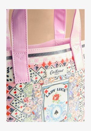 Värviline kott, millel on lillemustrid, täringud ja kaart "Lady Luck" disain, roosad käepidemed ja Cath Kidstoni silt.