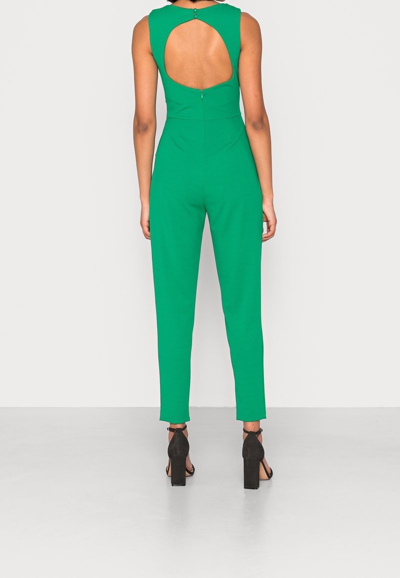 Green jumpsuit with a sleeveless design, open back, and zip closure. Made of smooth fabric, fitted at the waist and straight-leg.